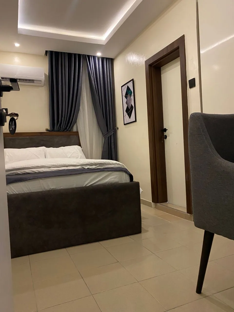 Dimple 44 guest room — queen bed with feature curtains and accent chair